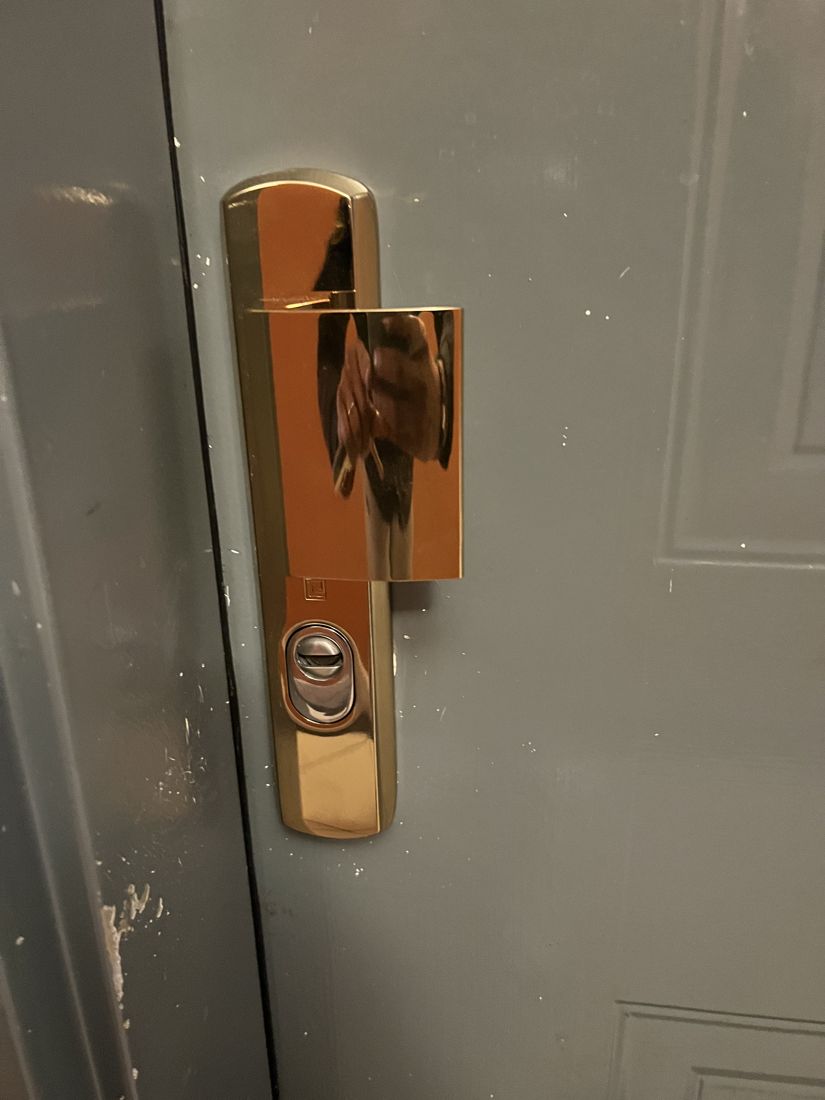 Garniture anti-effraction dorée et cylindre haute sécurité posés sur une porte d'appartement à Enghien-les-Bains (95)