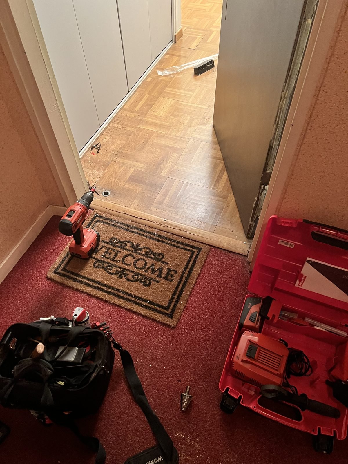 Intervention serrurier en cours à domicile : pose de porte avec outils Hilti