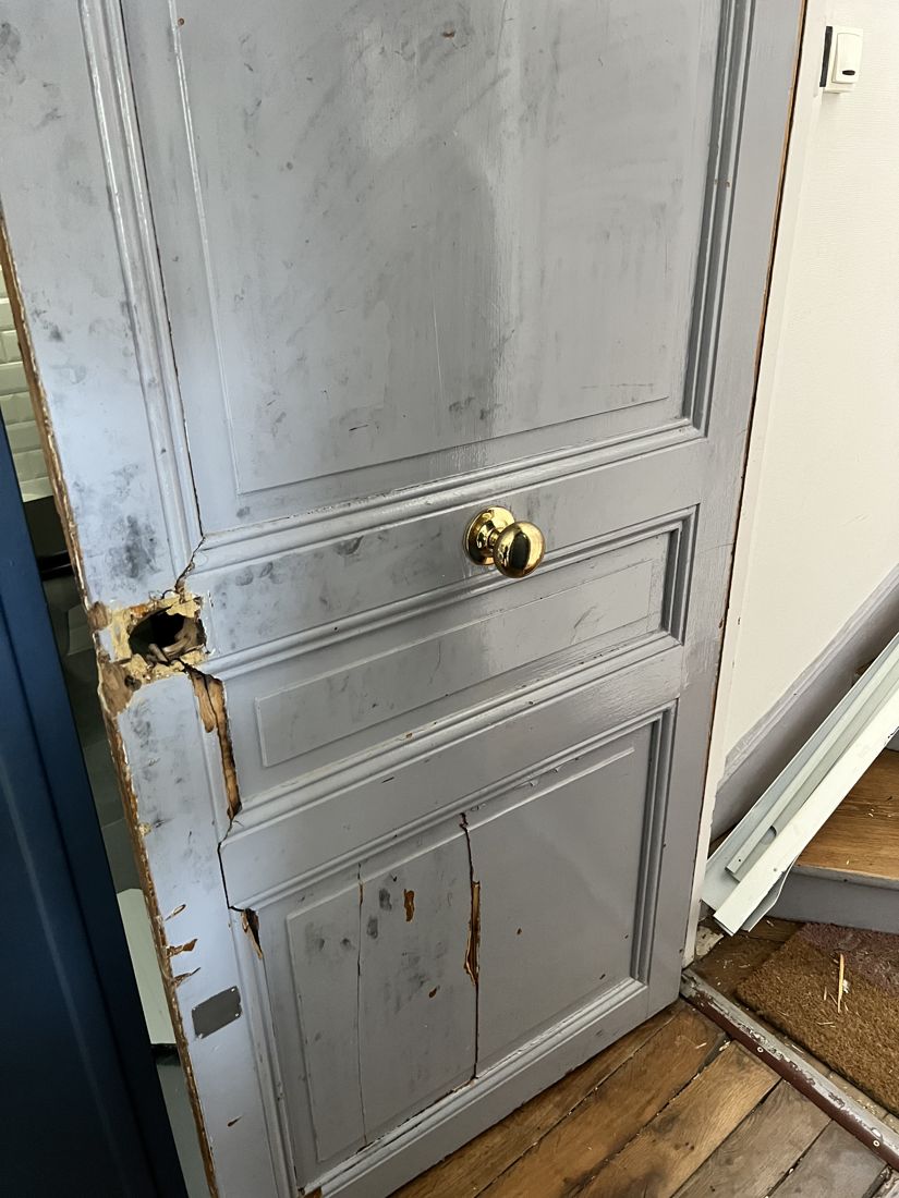 Avant : porte d'entrée fracturée lors d'un cambriolage, bois éclaté autour de la serrure